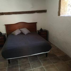 a bedroom with a bed with two pillows on it at Souterrain für max 2 P., Bad, Außenküche, Garten in Güimar