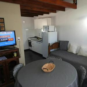 sala de estar con mesa, sofá y cocina en Amancay, en Villa Elisa
