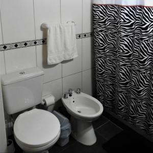 ein Badezimmer mit einem weißen WC und einem Waschbecken in der Unterkunft Amancay in Villa Elisa
