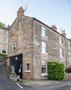 an old brick building with a black garage at Hope Terrace in Matlock