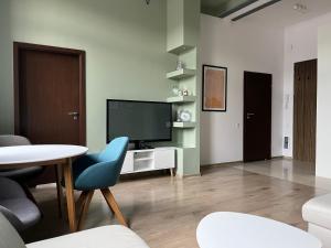 綠山城的住宿－Loft Stara Tkalnia，客厅配有电视和桌椅