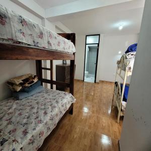 a bedroom with two bunk beds and a wooden floor at Apartamento viaje de estudio in Huancayo