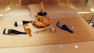 un grupo de botellas de champán en una cama en PARADIS CHAMBRES D'HÔTES PROCHE PARIS - AÉROPORT CHARLES DE GAULLE AIRPORT - PARC DES EXPOSITION VILLEPINTE - DYSNAYLAND PARIS., en Tremblay-en-France
