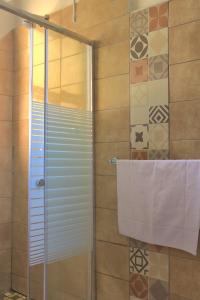 eine Dusche mit Glastür und ein Handtuch in der Unterkunft Grandborough in Durban