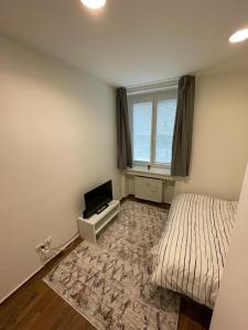 a bedroom with a bed and a television and a window at Luxury 2bed flat with free parking in Bratislava