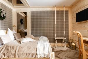 een slaapkamer met een bed met een schommel bij Brzozowa Osada - Premium Chalets Zakopane in Zakopane