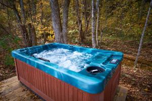 a hot tub sitting on a deck in the woods at Creekwalk Inn Bed and Breakfast with Cabins in Cosby