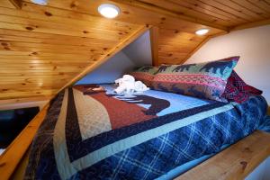 Ce lit se trouve dans un dortoir doté d'un plafond en bois. dans l'établissement Creekwalk Inn Bed and Breakfast with Cabins, à Cosby