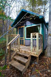 a tiny house with a staircase in the woods at Creekwalk Inn Bed and Breakfast with Cabins in Cosby