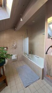 La grande salle de bains est pourvue d'une baignoire et d'un lavabo. dans l'établissement Chambre dans Maison Campagnarde, à Présilly