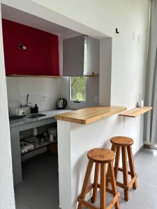 una cocina con 2 taburetes de madera en un mostrador en Complejo Las Palmeras, en Colonia del Sacramento