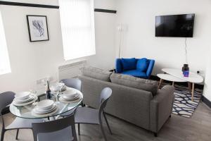 a living room with a couch and a table and chairs at Bootle, Liverpool Modern 1Bed Ft in Liverpool