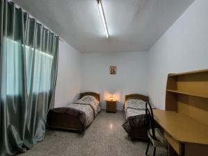 Pokój z 2 łóżkami, biurkiem i stołem w obiekcie Spacious 3 room apartment Prime Location on 2nd Floor with proximity to all amenities w mieście Safakis