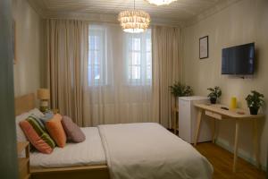 a bedroom with a bed and a television and a chandelier at HOUSE KA TEKKE ROOM in Canakkale