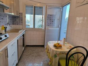 una cocina con una mesa con un bol de fruta. en Spacious 3 room apartment Prime Location on 2nd Floor with proximity to all amenities en Sfax