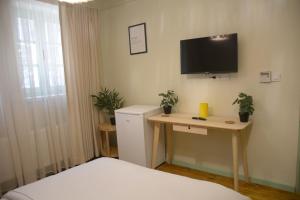 1 dormitorio con escritorio y TV en la pared en HOUSE KA TEKKE ROOM, en Canakkale