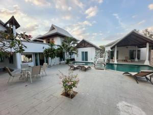 a house with a patio and a swimming pool at Pheonix Golf Pool Resort Villa in Ban Huai Yai