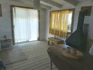 ein Wohnzimmer mit einem Tisch und einem großen Fenster in der Unterkunft El Descanso in Neptunia