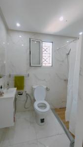 a bathroom with a toilet and a sink and a window at Maison d'hôtes Dar Ranim Tozeur in Tozeur