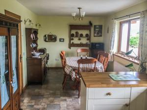 a kitchen with a table and chairs and a dining room at Scridain View in Bunessan