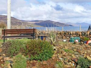 a bench in a field with a view of the water at Scridain View in Bunessan
