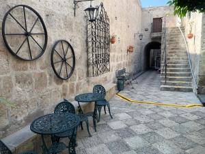 a patio with tables and chairs next to a wall at Hotel Los Tambos Colonial in Arequipa