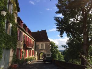 alejka w starym budynku z samochodem zaparkowanym na ulicy w obiekcie Les chambres d'hôtes au bon accueil w mieście Limeuil