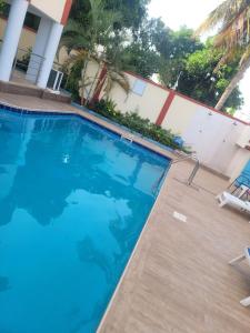 a swimming pool at a hotel with blue water at Executive Studio Apartment in East Legon