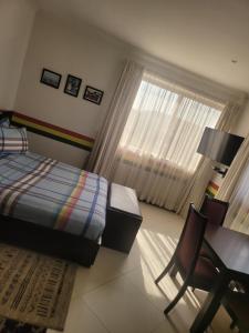 a bedroom with a bed and a desk and a window at Executive Studio Apartment in East Legon