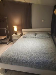 una camera con letto e lampada su comodino di Grande Chambre a Poissy