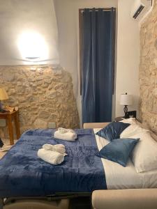 a bedroom with a blue bed with towels on it at Grotta Abati in Gaeta