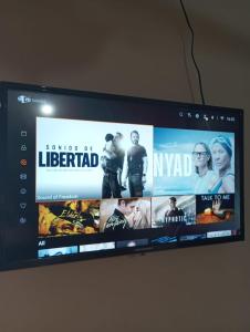 - une télévision à écran plat avec un film dans l'établissement Hostal EL VALLE, à Los Algarrobos