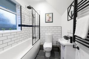 a white bathroom with a toilet and a sink at The Blue House by Luke Stays in Bearpark