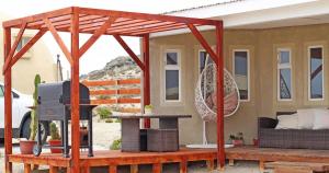 ein Haus mit einer Terrasse mit einem TV und einem Tisch in der Unterkunft Entre Dunas y Caracolas in Punta de Choros