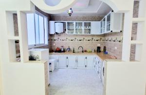 a kitchen with white cabinets and a sink at Beach Appartment close to Marina 105 sqm in Agadir