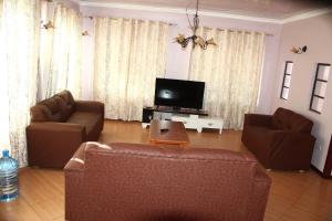 a living room with a couch and a tv at Ms Safari in Thika
