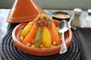 un tazón de comida con zanahorias y judías y una cuchara en Dar Nomad Tagounite en Zagora