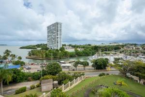 a tall building next to a body of water at Luxury Apartment with Ocean Views in Fajardo