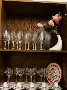 a bunch of wine glasses on a shelf with a vase at La Palma apartment in Vigevano