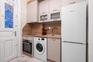 a kitchen with a washing machine and a refrigerator at Ω Omega, Nilie Hospitality MGMT in Thessaloniki