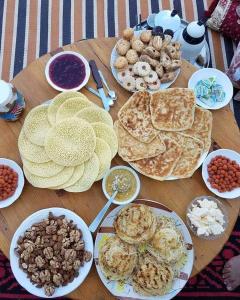 a wooden table topped with plates of food and snacks at Dar Nomad Tagounite in Zagora