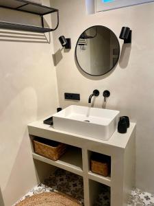 uma casa de banho com um lavatório branco e um espelho. em Neue Hafenliebe em Neustadt in Holstein