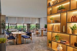a restaurant with a table and chairs and shelves at PARKROYAL Serviced Suites Jakarta in Jakarta
