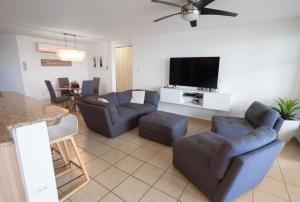 a living room with couches and a flat screen tv at Luxury Apartment with Ocean Views in Fajardo