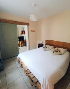 1 dormitorio con 1 cama blanca grande y 2 almohadas en Gîte du Flotteur, en Chevroches