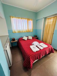 - une chambre avec un lit rouge et des serviettes dans l'établissement Gran Hotel de los Acantilados, à Mar del Plata