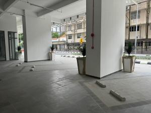 an empty hallway with potted plants in a building at The Riveria City Brickfield by GoMain in Kuala Lumpur