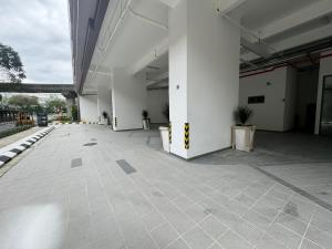 een leeg gebouw met witte zuilen en planten erin bij The Riveria City Brickfield by GoMain in Kuala Lumpur