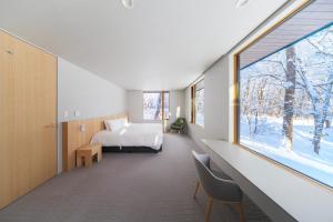 una camera da letto con un letto e una grande finestra di Villa Lily by Hakuba White Fox Company a Hakuba