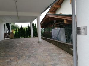 a white building with a porch with a fence at Appartement Mayrl in Fieberbrunn